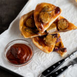 Currywurst Flammkuchen Variante, belegt mit Currywurst Tomatensosse und Zwiebeln