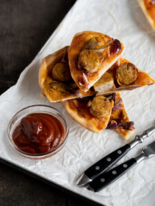 Currywurst Flammkuchen Variante, belegt mit Currywurst Tomatensosse und Zwiebeln