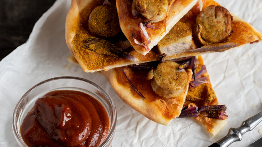 Currywurst Flammkuchen Variante, belegt mit Currywurst Tomatensosse und Zwiebeln