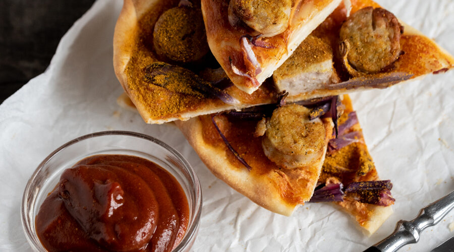 Currywurst Flammkuchen Variante, belegt mit Currywurst Tomatensosse und Zwiebeln